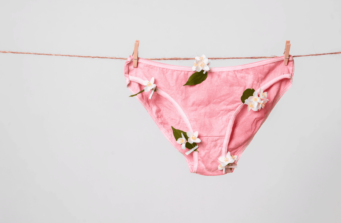 Ein rosa Frauenslip mit Blumen hängt an einer Wäscheleine